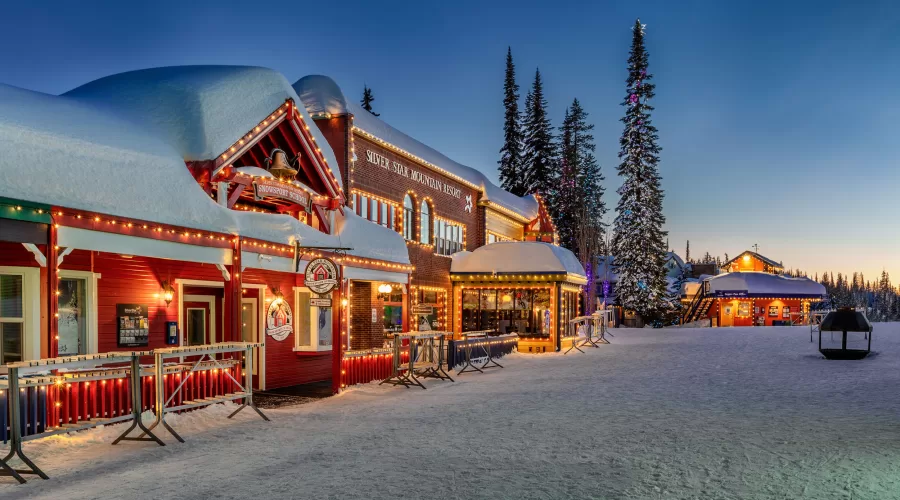 The village at SilverStar aglow with twinkling lights as the sun sets in Vernon, BC.