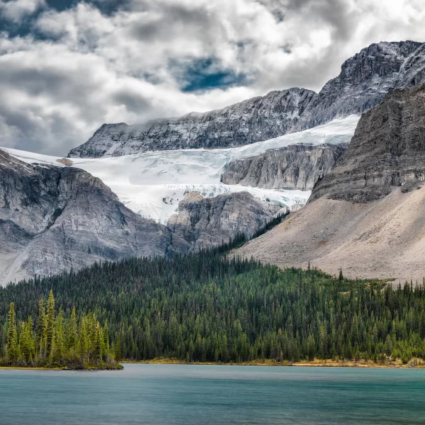 Expansive views of an ancient glacier, pristine mountain lake, and sweeping alpine valley along the Ice Fields Parkway between Banff and Jasper.