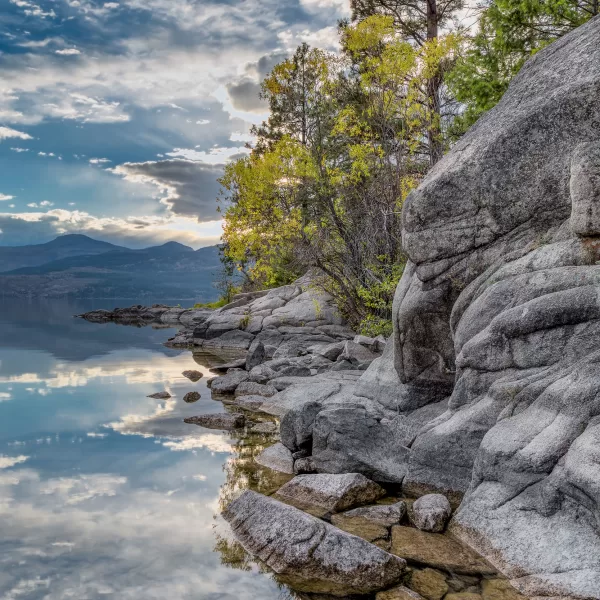 The beauty of Ellison Park reflected onto the surface of tranquil Okanagan Lake, melts into the rocks below.